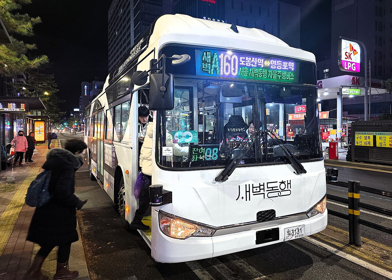 Passengers boarding a white Seoul A160 autonomous bus at a street stop